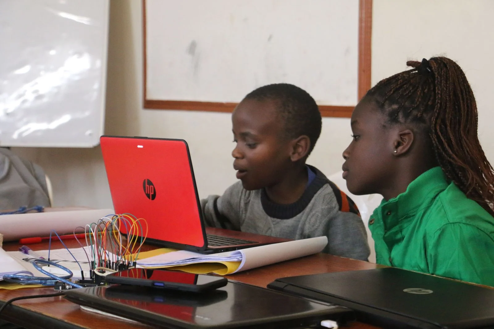 An instructor supporting a learner at a laptop