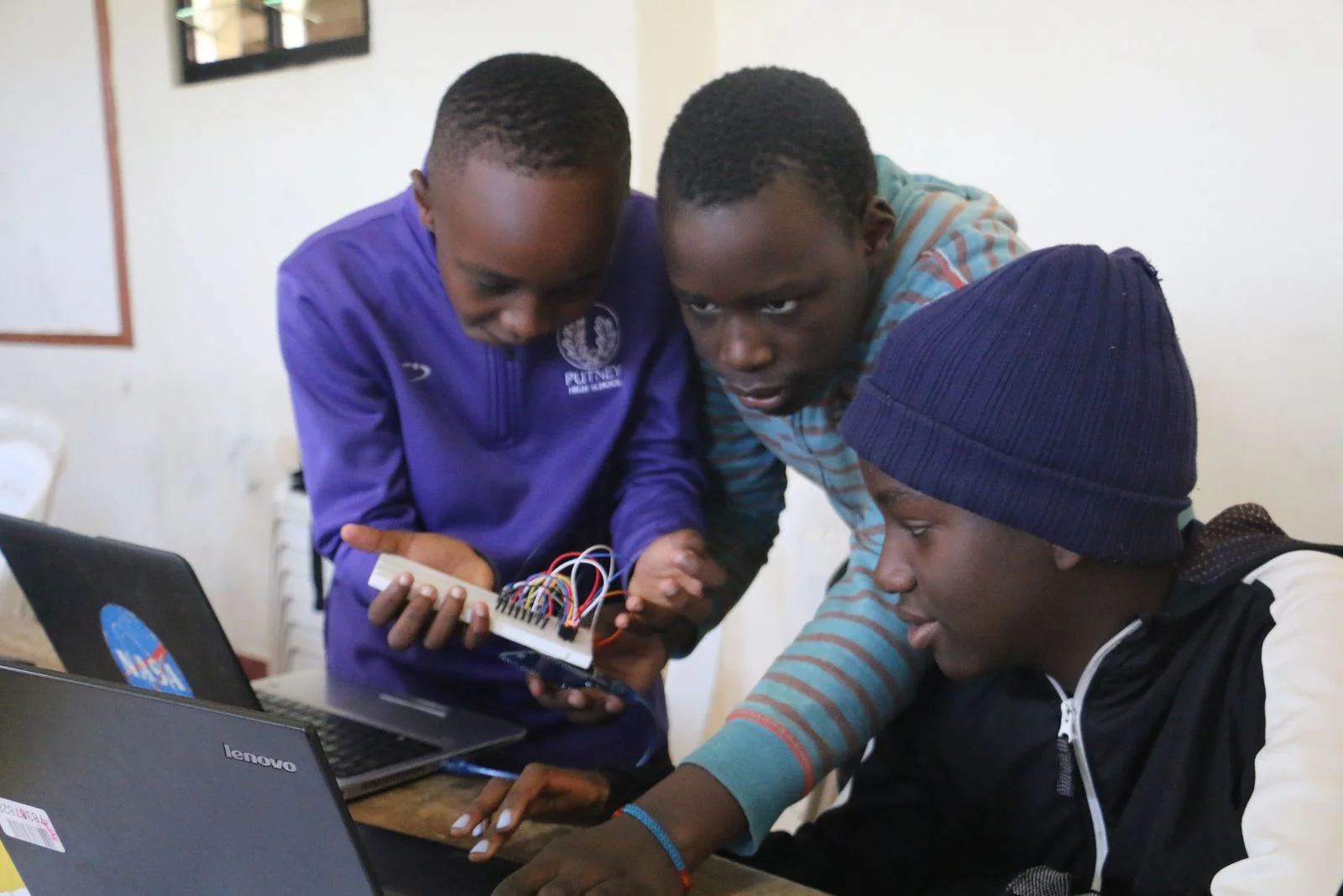 Learners and an instructor working together on electronics